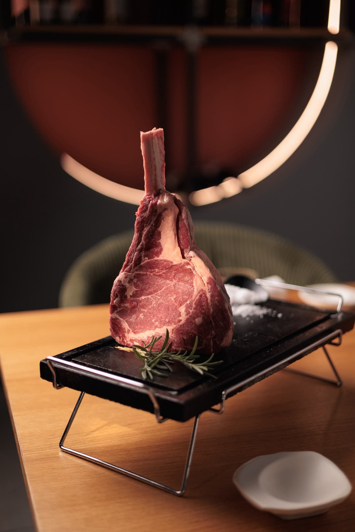 Tomahawk crudo su pietra con rosmarino e sale